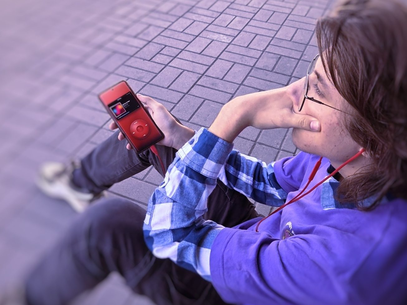 The player up close in one hand, cover art at the top and the wheel underneath.